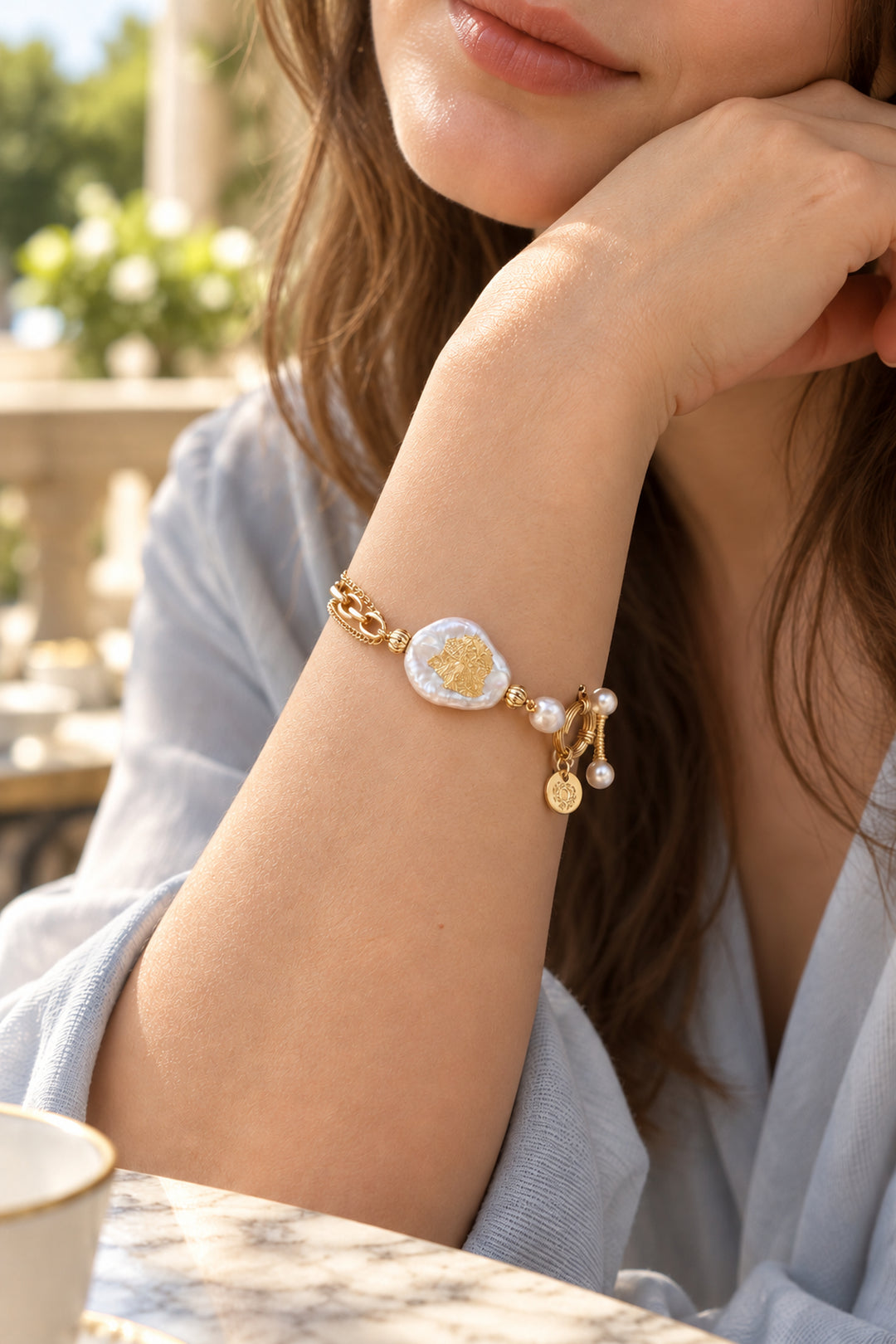 Nahaufnahme des APAERZ AURELIA Armbands mit goldfarbenem Ringelement und perlenbesetztem OT-Verschluss am Handgelenk