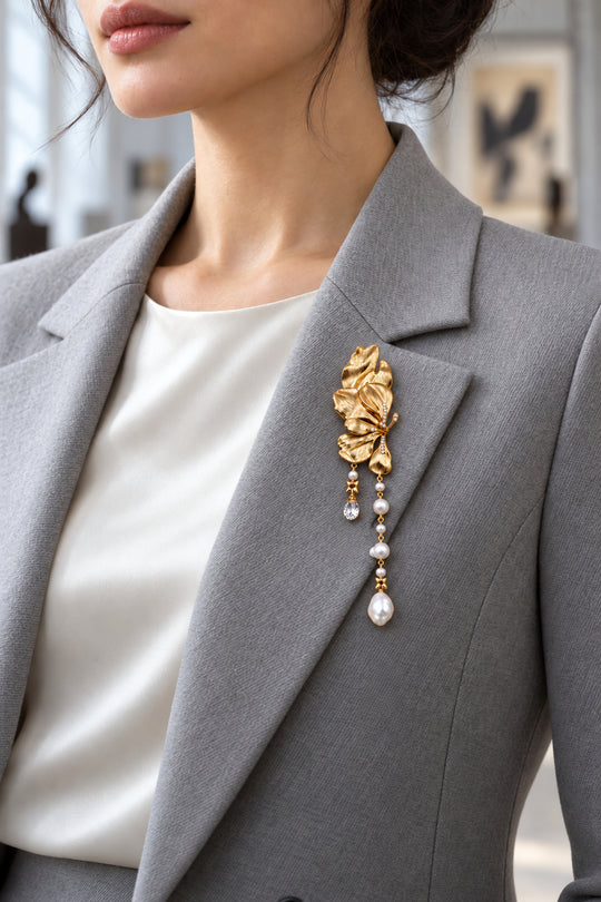 APAERZ CAMELIA Blütenbrosche mit Barockperlen und Zirkonia am Revers eines grauen Blazers