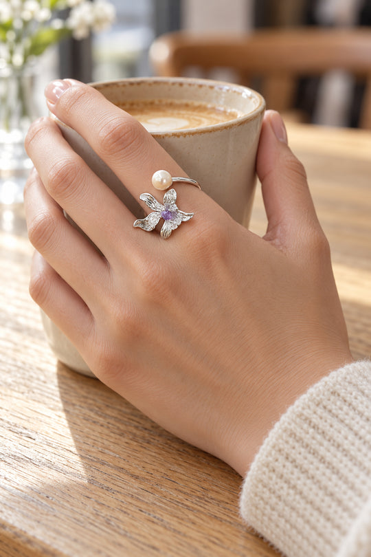 APAERZ FIORELLA Blütenring mit Süßwasserperle an einer Hand, die eine Kaffeetasse hält