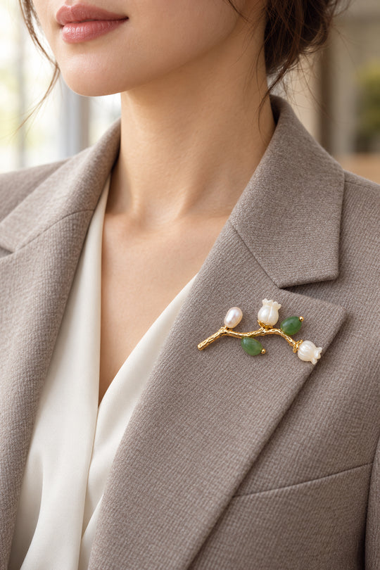 APAERZ VERENA Zweigbrosche mit Aventurin und Perlmuttblüten am Revers eines hellen Blazers